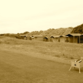 A row of beach huts sit tucked in between the 16th hole and the adjacent foredune.